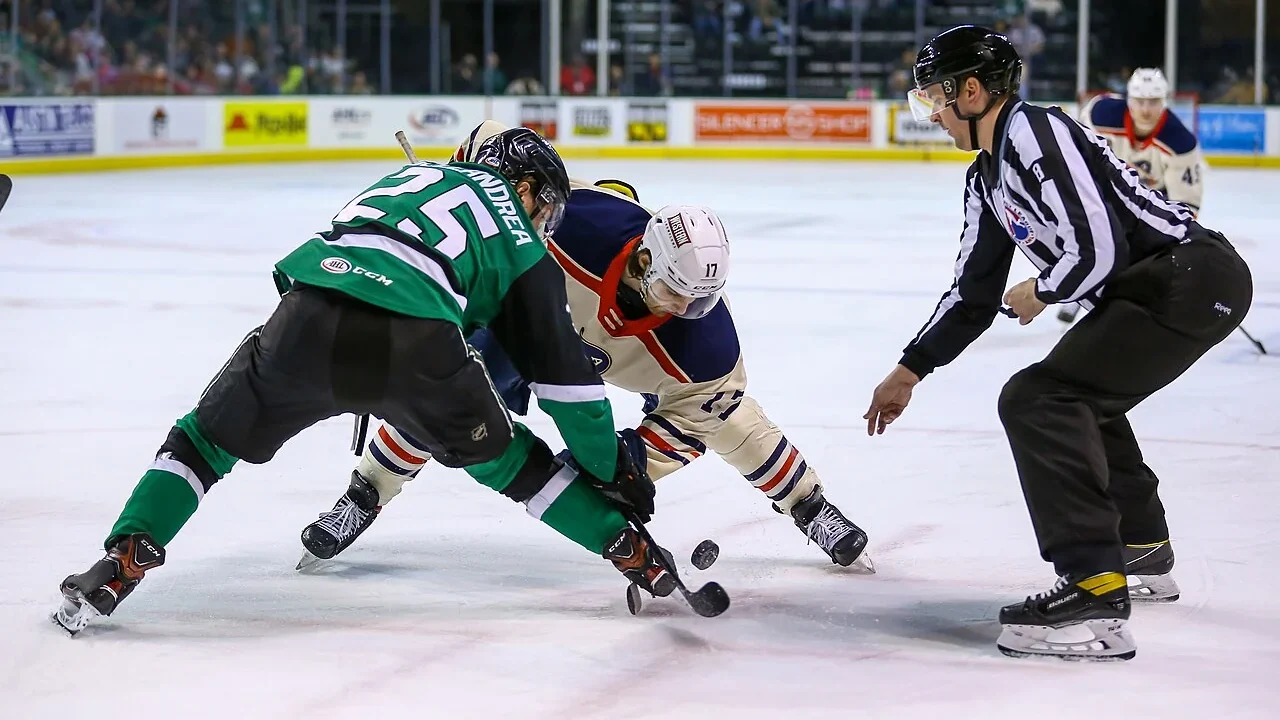 Ein Linienrichter und zwei Spieler beim Anspiel zwischen Texas Stars und Milwaukee Admirals im März 2022